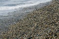 pebble beach washed by sea waves, small and various stones forming the shore