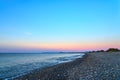 Pebble beach with waves on a sunset. Crete, Greece. Royalty Free Stock Photo