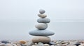 Pebble cairn, stack of smooth pebbles on the seaside. Stone stack on the beach near a calm misty ocean. Generative AI Royalty Free Stock Photo