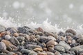 Pebble gravel stones sea water splash defocused bokeh lights nature background. Natural beach stones background