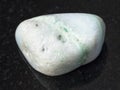 pebble of green Aragonite gemstone on dark