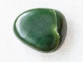 pebble of green nephrite gemstone on white