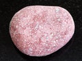 pebble of pink Arkose sandstone on dark background Royalty Free Stock Photo