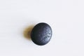 Pebble polished shungite tumbled stone on a white background with blank space