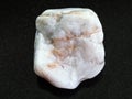 Pebble of rough marble stone on dark background