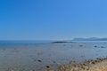 Pebble sea shore and clear blue sky.