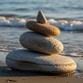 Pebble stack by the shore at sunset. Four smooth stones in varying shades of gray an Royalty Free Stock Photo