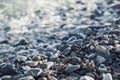 Pebble stones on the shore close up in the blurry sunset light in the distance background Royalty Free Stock Photo