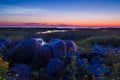 Pebble stones on the shore close up in the blurry sunset light in the distance background Royalty Free Stock Photo