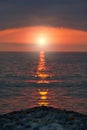 Pebble stones on the shore close up in the blurry sunset light in the distance background. Royalty Free Stock Photo