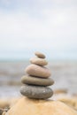 Pebble tower on sunny beach sea wave splashing water balance pyramid harmony peace of mind Royalty Free Stock Photo