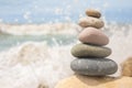 Pebble tower on sunny beach sea wave splashing water balance pyramid harmony peace of mind Royalty Free Stock Photo