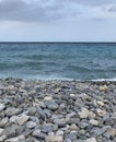 Pebbles on the beach with blue sea and cloudy sky Nice Royalty Free Stock Photo