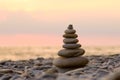 Pebbles on the beach in the form of a pyramid against the backdrop of the sea and sunset. Royalty Free Stock Photo