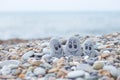 Pebbles with drawn faces in the sand. Father, mother and daughter. Family vocation concept