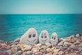 Pebbles with drawn faces in the sand. Father, mother and daughter. Family vocation concept