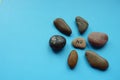 Pebbles in the form of a flower on a blue table. The main stone is in the center with no text on it Royalty Free Stock Photo