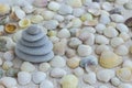 Pebbles lined with pyramid on the background of seashells