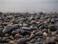 Pebbles on the seashore close-up. Rocky beach. Stones close-up with bokeh. Gray natural background. Autumn on the seashore
