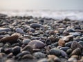 Pebbles on the seashore close-up. Rocky beach. Stones close-up with bokeh. Gray natural background. Autumn on the seashore