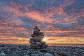 Pebbles stack on sea rocky beach with sea and sunset sky background Royalty Free Stock Photo