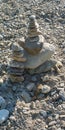 Pebbles stacked on top of each other to form a small tower, layered, on Lake Como