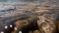 Pebbles stone underwater below water surface near lake shore, natural scene Royalty Free Stock Photo