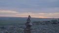 Pebbles tower Zen and balance. Stack of the pebbles against the sky. Tower of stones on the background of the field and Royalty Free Stock Photo