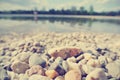 Pebbly lake shore on a sunny summer afternoon, vintage Royalty Free Stock Photo