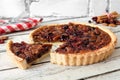 Pecan cranberry pie with slice removed on white wood Royalty Free Stock Photo