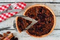 Pecan cranberry pie table scene with slice being removed