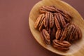 Pecan nut close-up in spoon on brown background.Healthy fats.Heap shelled Pecans nut . Ingredient of the keto diet.Tasty