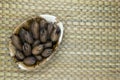 Pecan Nuts with the Nutshell in Eco Natural Banana Leaf Plate on Natural Bamboo Mat Surface with Free Space Royalty Free Stock Photo