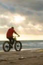 pedaling on the beach against the sun