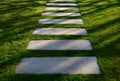 Concrete path lawn pedal rectangular shape in regular grid routed directly through beautiful lawn suns and shadows stone Royalty Free Stock Photo