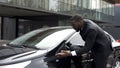 Pedantic and scrupulous man noticing dust on his car and coming into rage