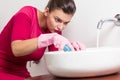 Pedantic woman cleaning washbasin