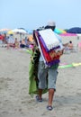Peddler of colorful towels by the sea on the beach