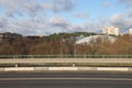 The pedestal and railing of the overpass across the highway against the backdrop of a busy highway, traffic, urbanism.