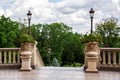 Pedestals with stone flowerpots with flowers.