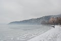 Pedestrian alley covered with snow on the banks of frozen lake Orestiada in Kastoria