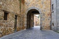 Pedestrian alley in medieval town with stone arch under old building. ÃÂvila,