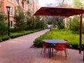 Pedestrian alley red umbrellas outdoor table and chairs in a new apartment complex Royalty Free Stock Photo