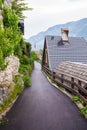 Pedestrian, asphalt road near old vintage wooden roofs of houses by the lake in Hallstatt, Austria Royalty Free Stock Photo