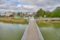 Pedestrian bridge over a river against the cloudy blue sky in Korn, Poland