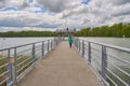 Pedestrian bridge over a river against the cloudy blue sky in Korn, Poland