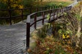 Pedestrian bridge over a small gorge and a stream. it consists of two steel crossbeams. as the surface and railing of the bridge i