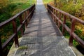 Pedestrian bridge over a small gorge and a stream. it consists of two steel crossbeams. as the surface and railing of the bridge i Royalty Free Stock Photo