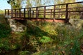 Pedestrian bridge over a small gorge and a stream. it consists of two steel crossbeams. as the surface and railing of the bridge i