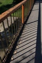 Pedestrian bridge rustic color railing and it's shadow Royalty Free Stock Photo